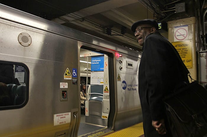 Wayne Mackie boards a commuter train headed home from his day job working on housing issues in New York City. He’s got Bears and Ravens video waiting for him.